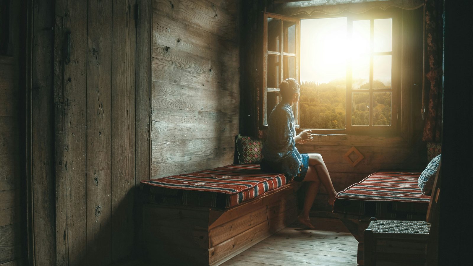 CBD for anxiety — peaceful person at window in soft morning light
