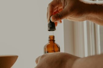 CBD dosage guide — hand holding amber dropper bottle in natural light