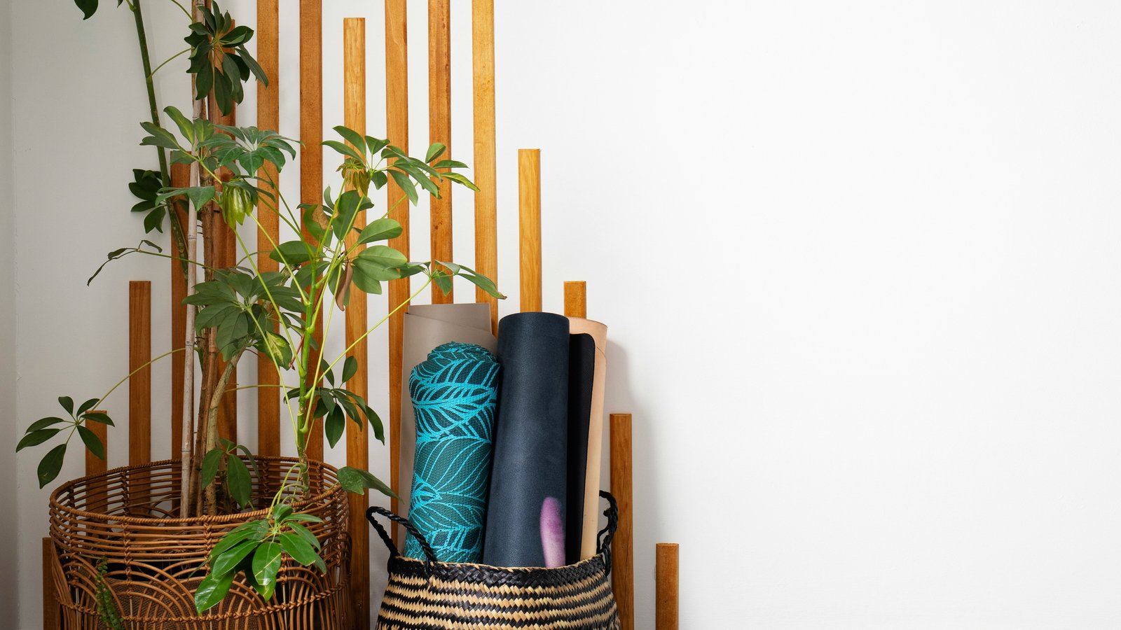 Wellness corner with plant, woven basket, and yoga mats — calm stretching practice space