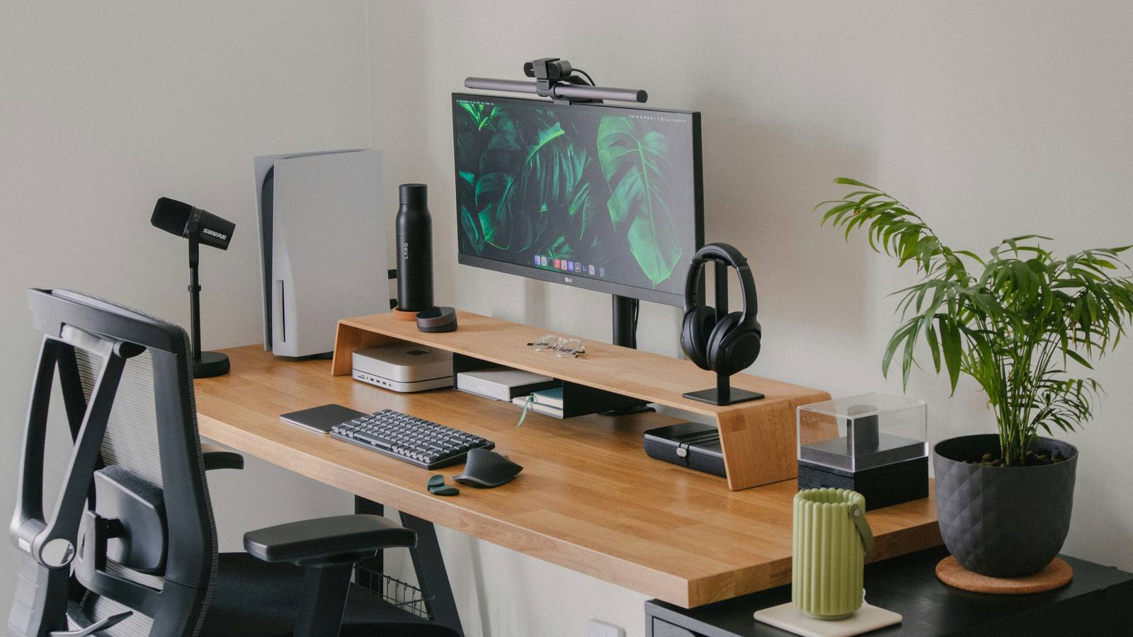 A tidy desk with the monitor raised to eye level on a stand and an ergonomic chair.
