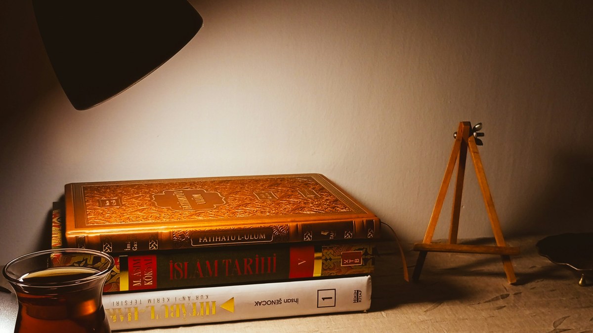 A cozy bedside lamp and books, a calm evening wind-down scene.