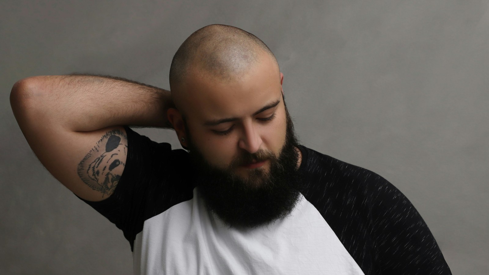 A person doing a gentle neck stretch, easing one ear toward the shoulder.