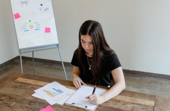 A person reviewing printed documents at a desk