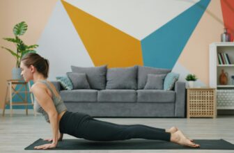 A person stretching on a mat in a living room