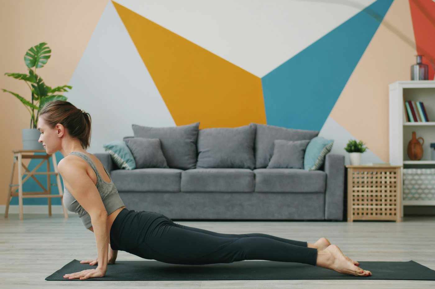 A person stretching on a mat in a living room