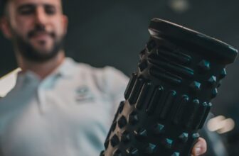 A man holding a foam roller in a gym