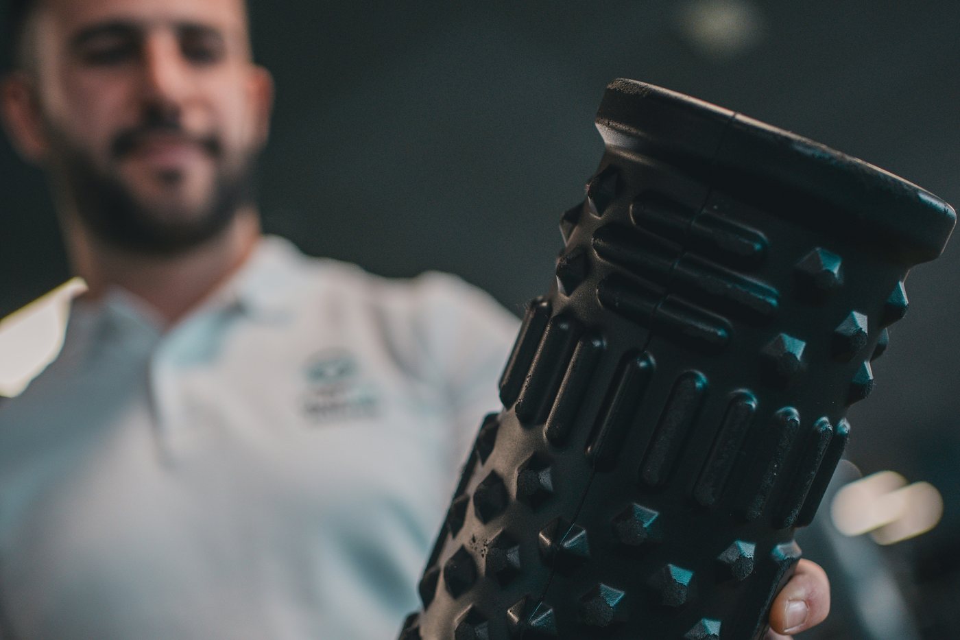 A man holding a foam roller in a gym