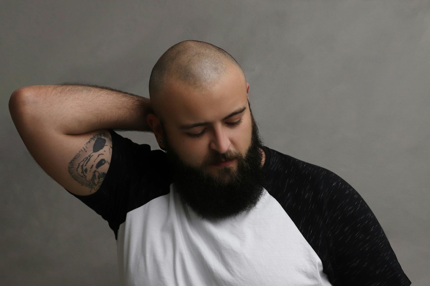 Portrait of a bearded man against a plain grey background
